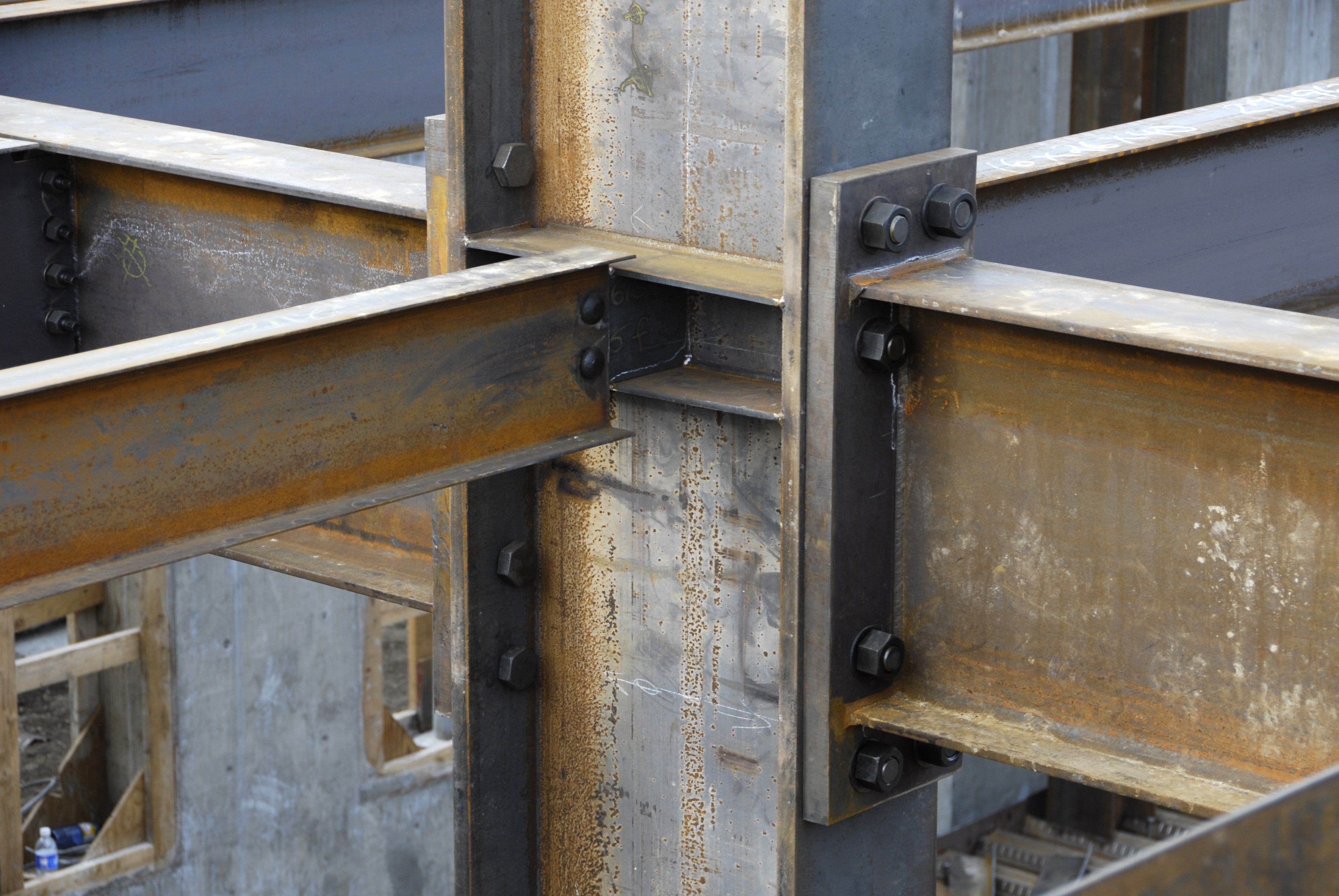 Simply supported beam in real life: steel beams bolted to a column with shear-tab connections